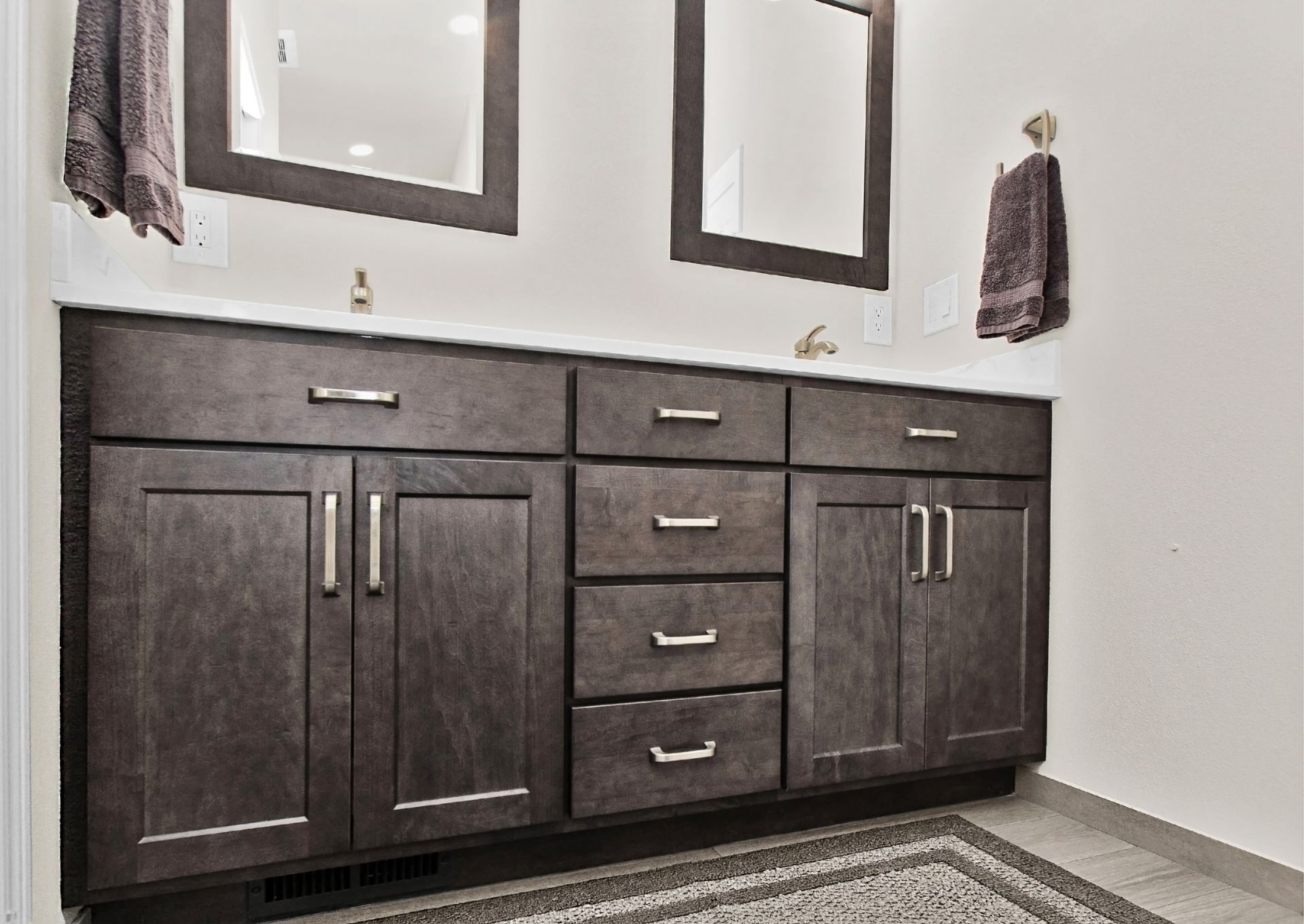 A bathroom with two sinks and a walk in shower.