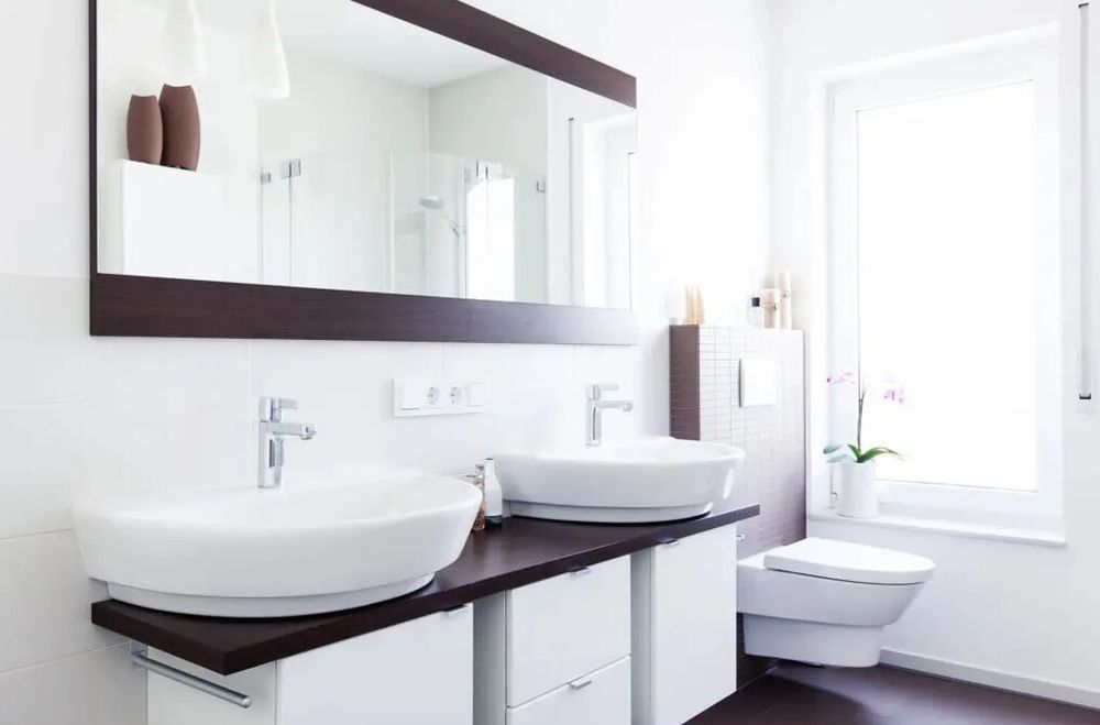 A bathroom with two sinks and a walk in shower.