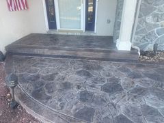 A concrete porch with steps and a flag in the background.