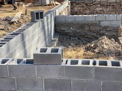 A brick wall is being built on a construction site