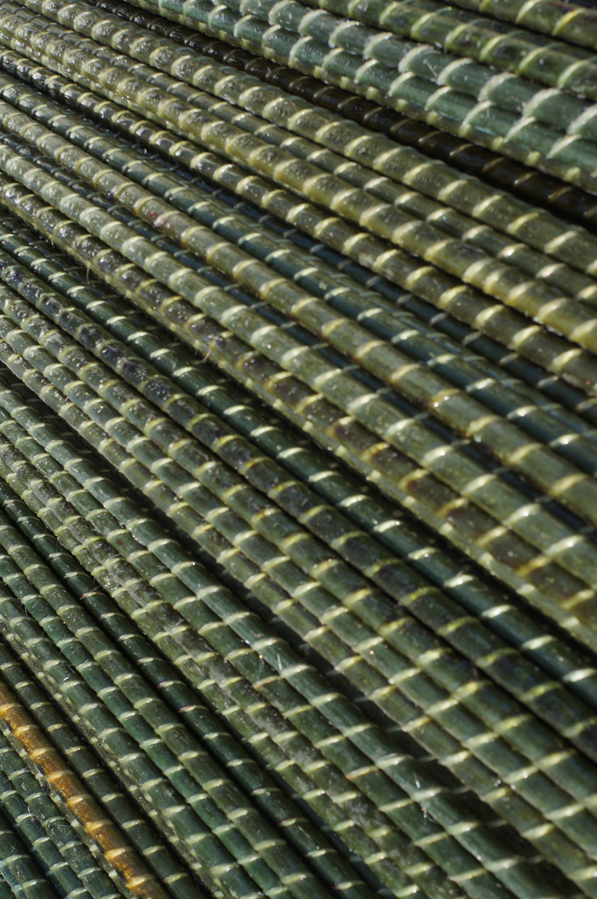 Rebar, steel reinforcing bars, stacked diagonally with textured surfaces.