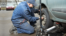A mechanic at work on a car wheel