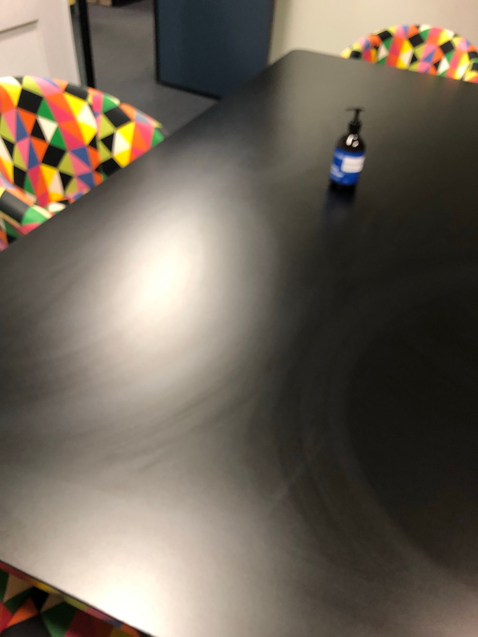 A black table with a bottle of hand sanitizer on it