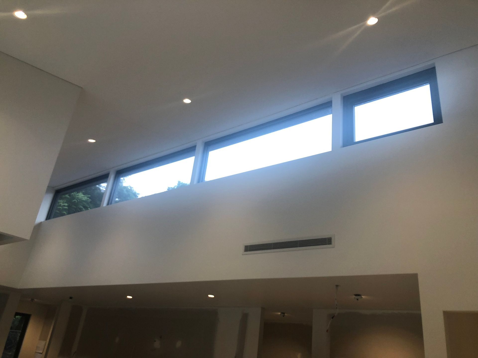 A room with a lot of windows and a ceiling that is very high.