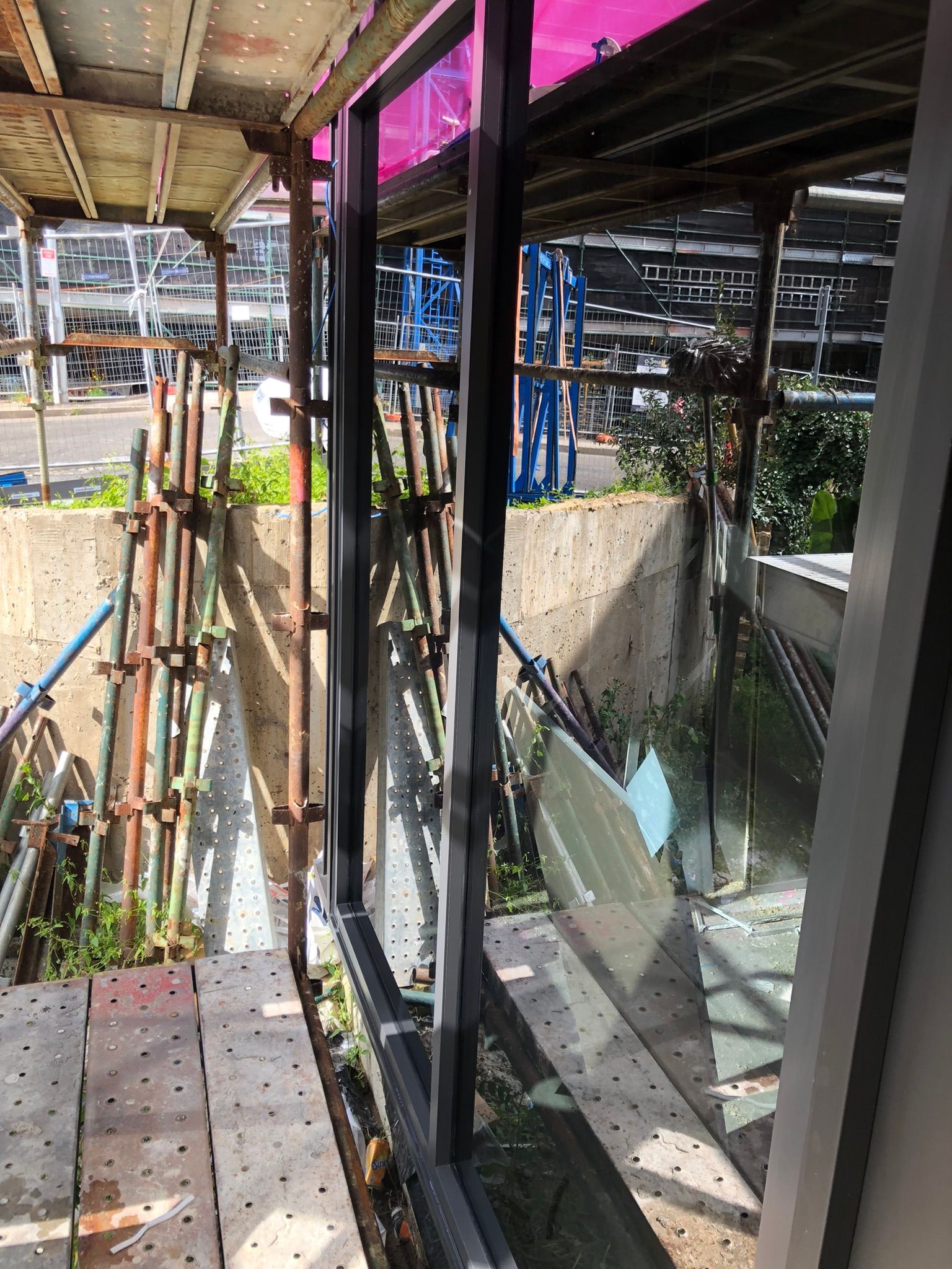 A building under construction with scaffolding and a window.