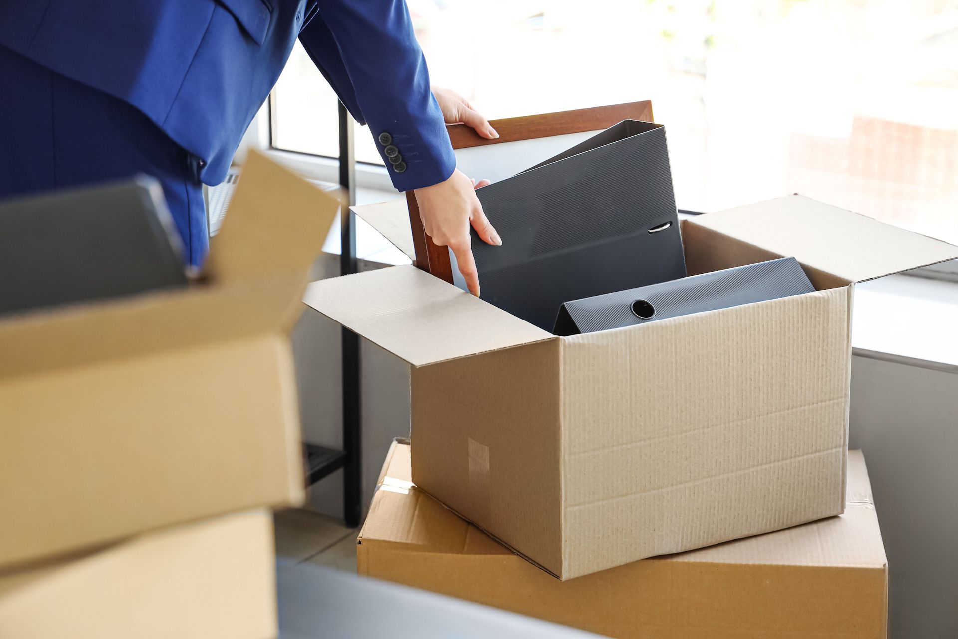 A man is opening a cardboard box with a laptop in it.