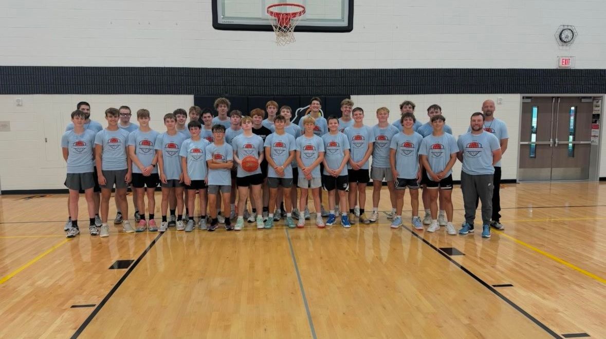 A group of girls are playing volleyball in a gym.