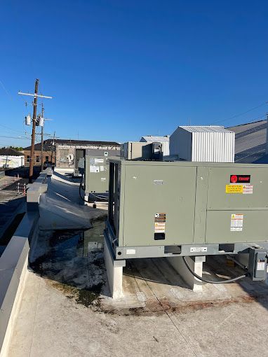 A large air conditioner is sitting on top of a building.