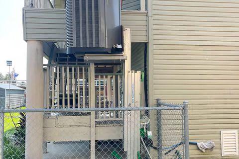 A building with a fence and a staircase on the side of it.