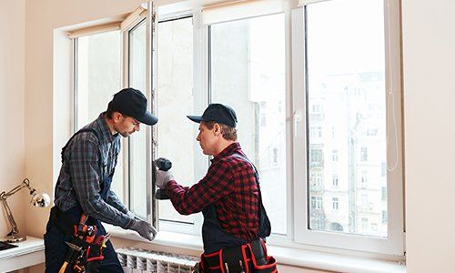 Insulated Glass — Construction Workers Installing New Window in Asheville, NC