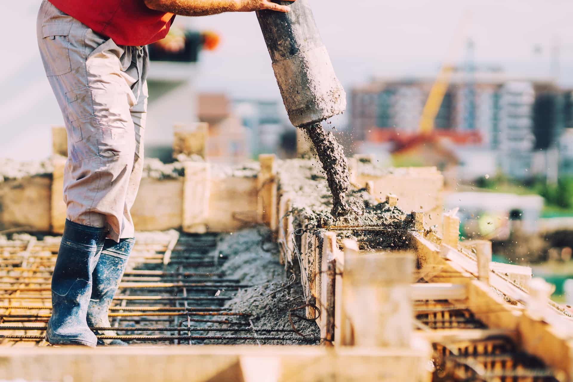 A Man is Pouring Concrete on a Construction Site — Aussie Mad Pumping In Bundaberg, QLD