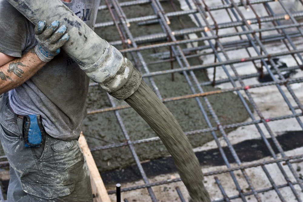 A Man is Pouring Concrete Into a Steel Structure — Aussie Mad Pumping In Bundaberg, QLD