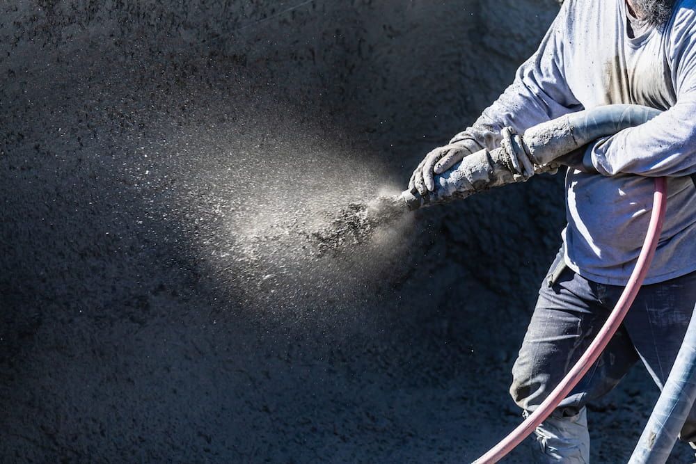 A Man is Spraying Concrete With a Hose — Aussie Mad Pumping In Maryborough, QLD