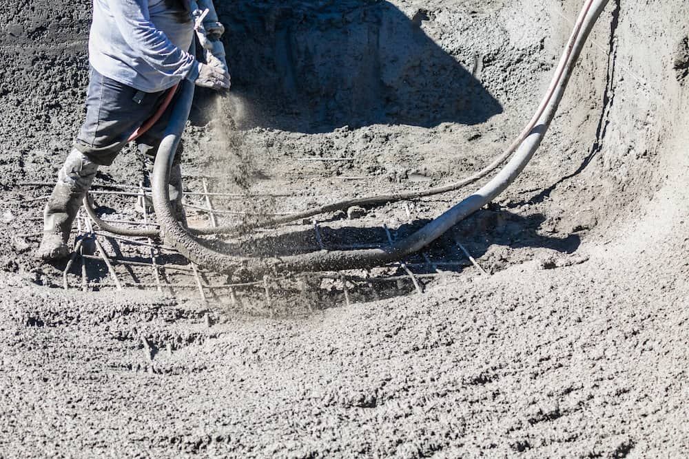 A Man is Pumping Concrete Into a Hole in the Ground — Aussie Mad Pumping In Hervey Bay, QLD
