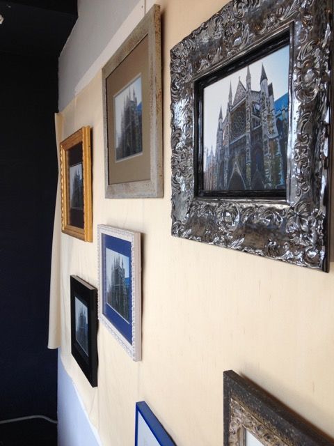 A row of framed pictures are hanging on a wall right view