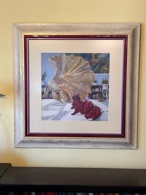 A framed picture of a cat and a seashell on a wall