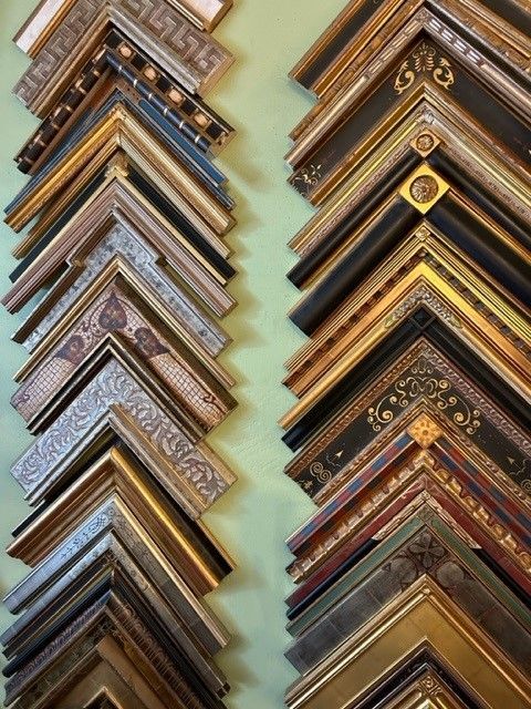 A bunch of picture frames are lined up on a wall