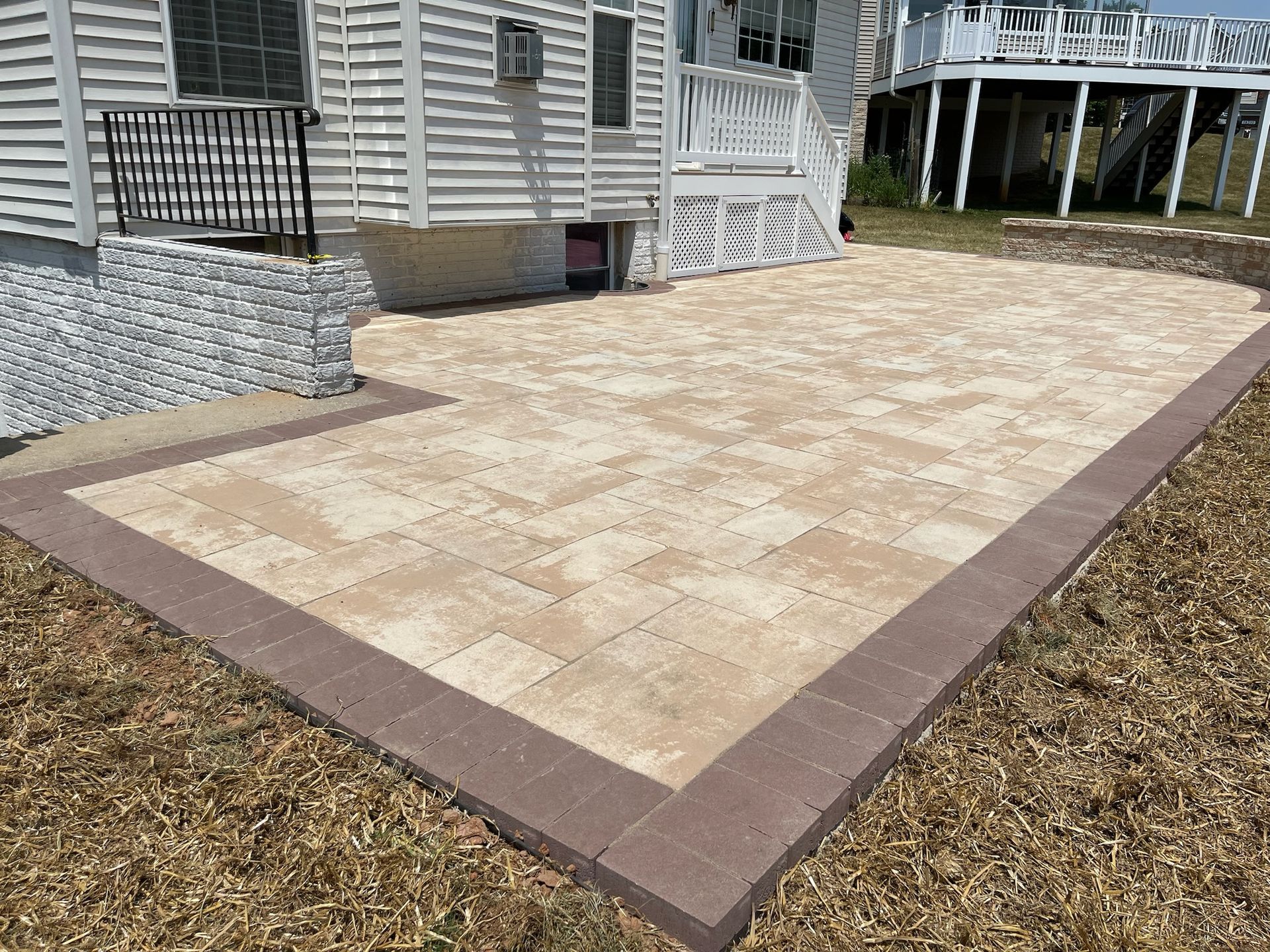 A patio with a brick border is in front of a mobile home.