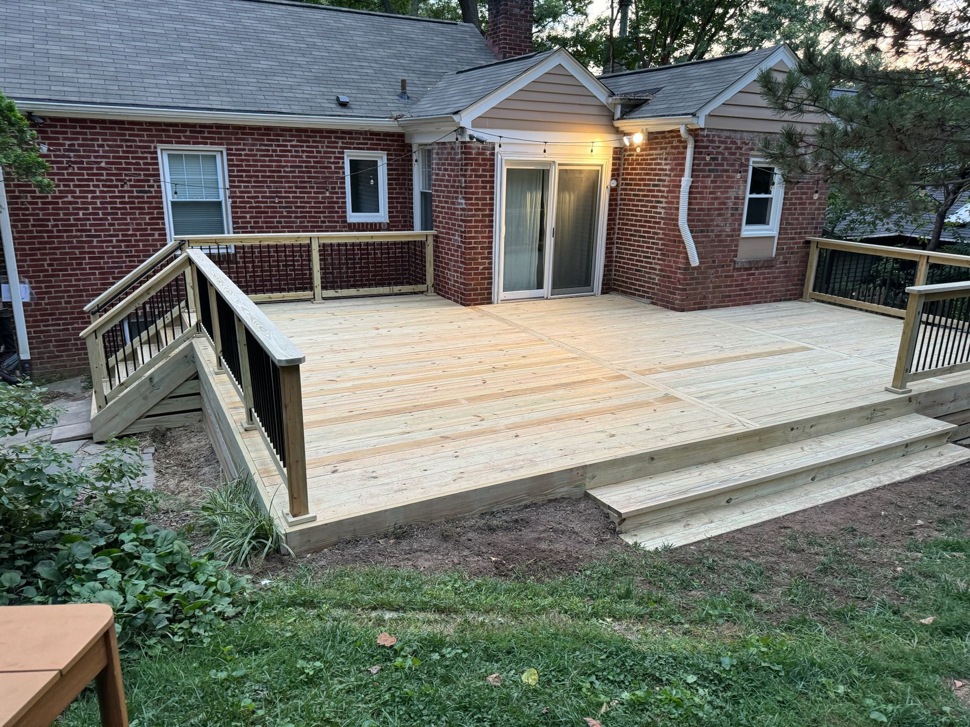 A brick house with a wooden deck in front of it.