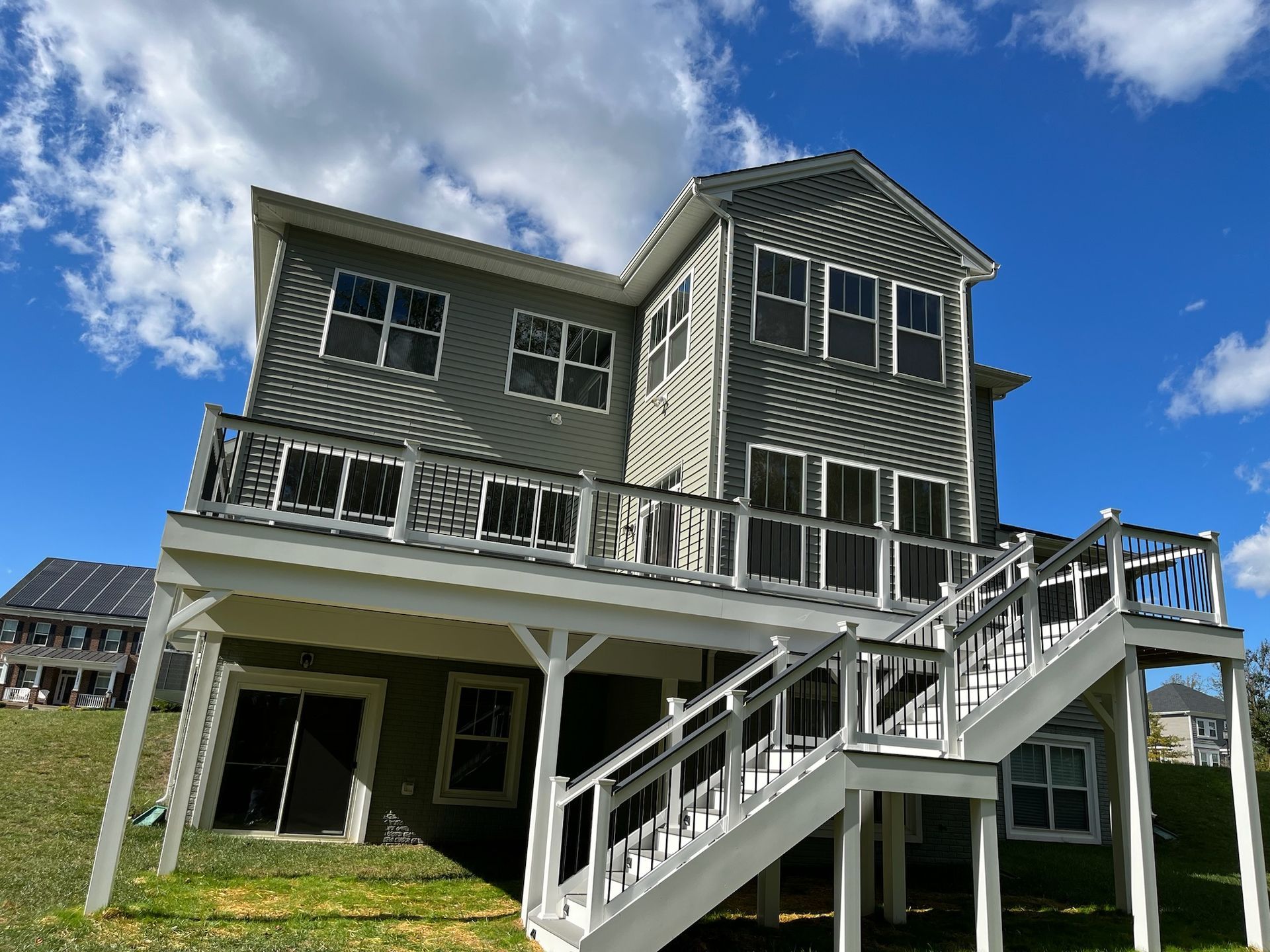 A large house with a large deck and stairs leading up to it.
