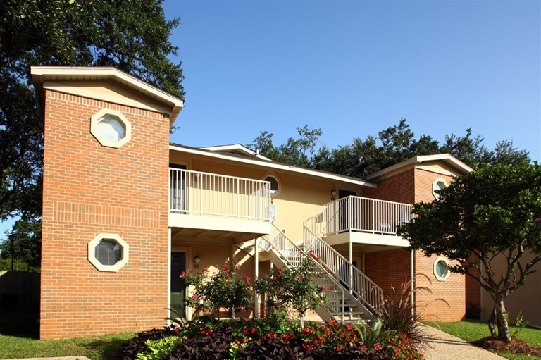 A brick apartment building with stairs leading up to the second floor