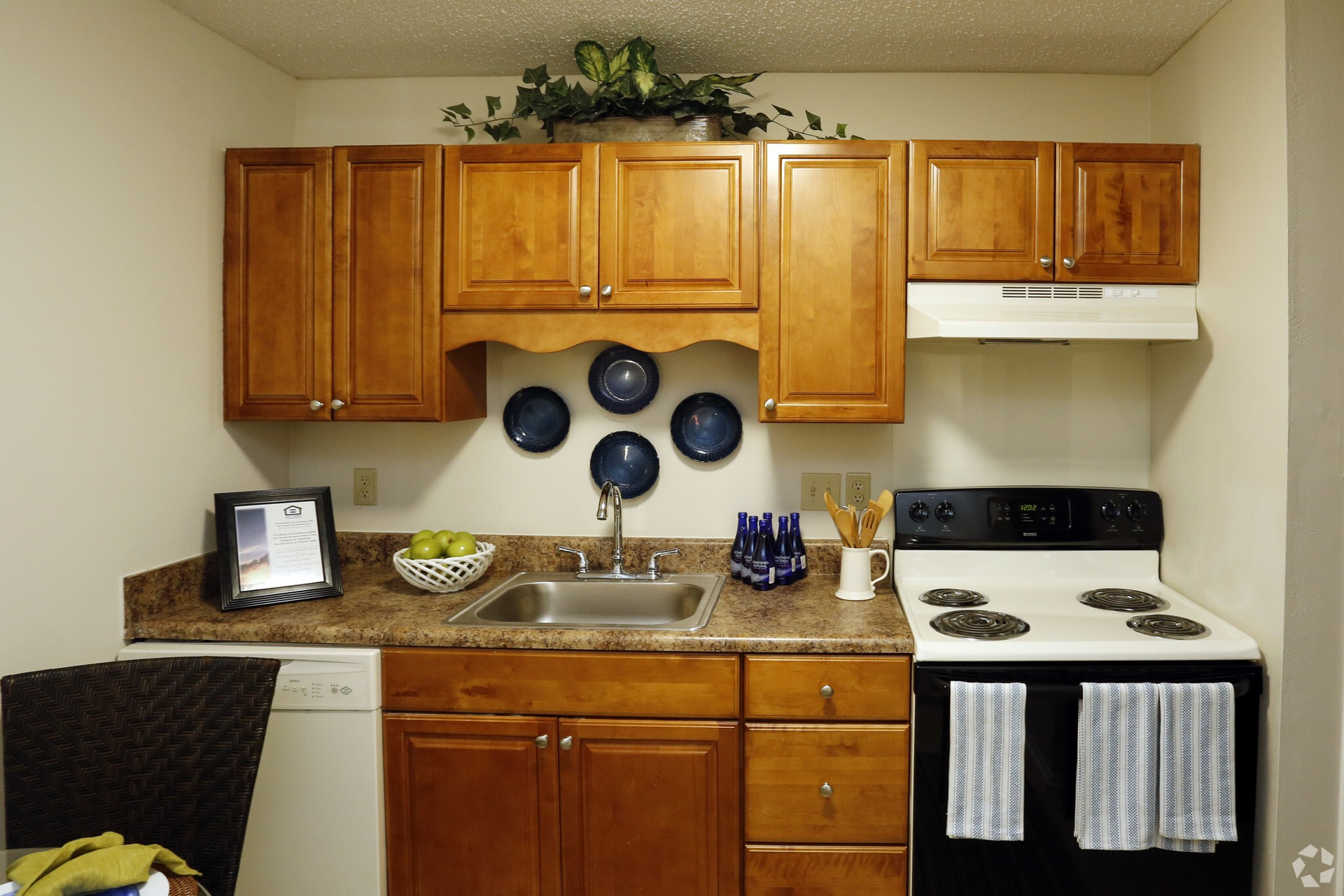A kitchen with wooden cabinets a stove and a sink
