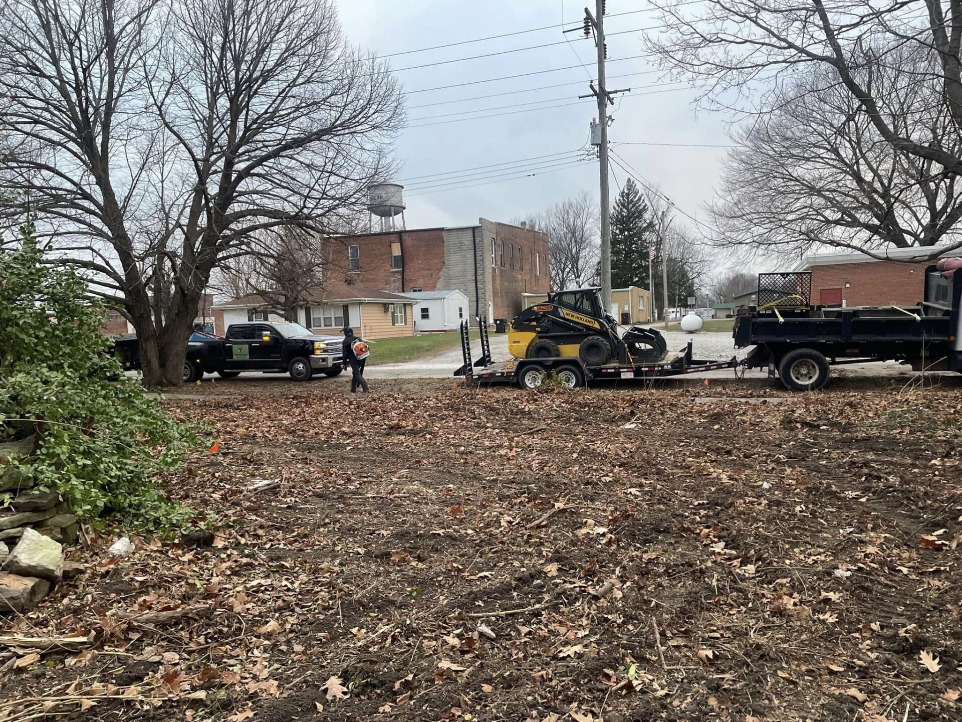 A truck is towing a tractor in a field.