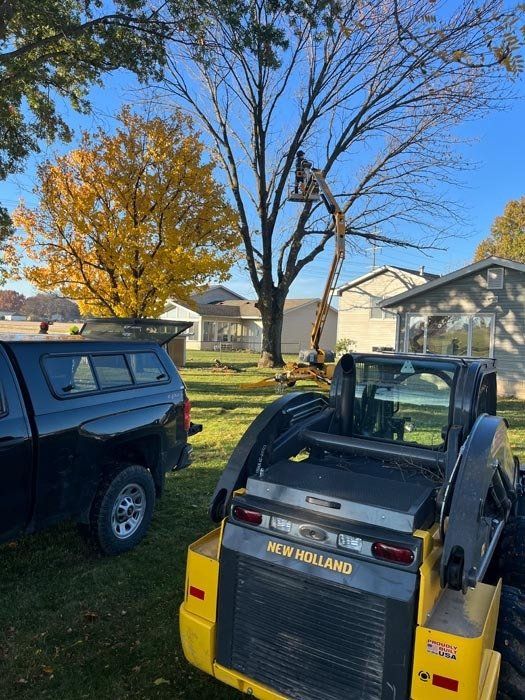 A black truck is parked next to a yellow tractor.