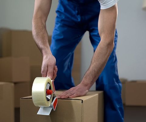 Moving Company Worker Packing Cardboard Boxes — Columbus, GA — Sanera Van Service Inc.