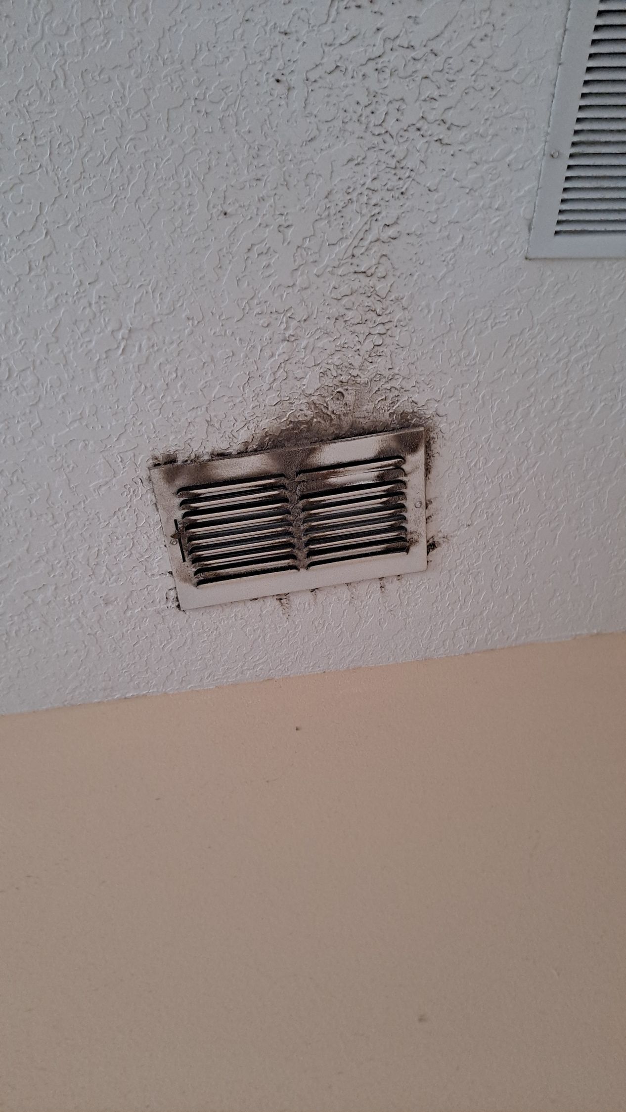 A close up of a vent on the ceiling of a room.