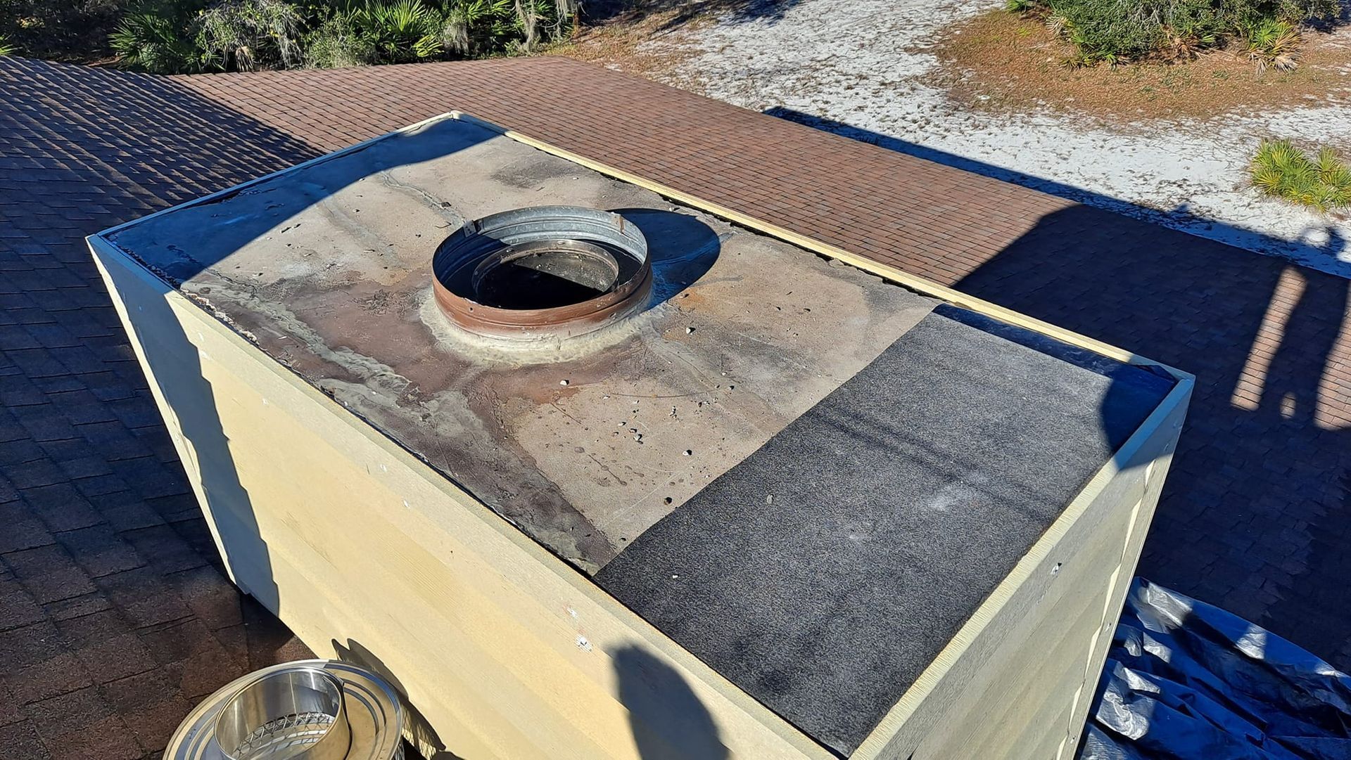 A wooden box with a hole in the middle is sitting on top of a brick roof.