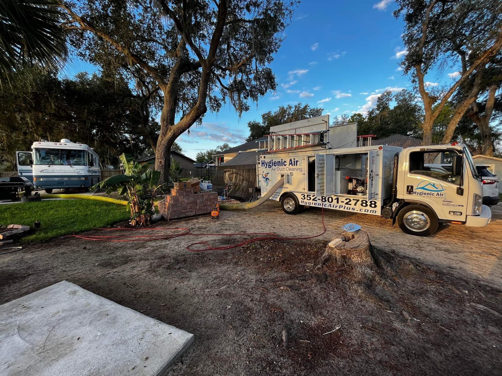 A truck is parked in a driveway next to a house.
