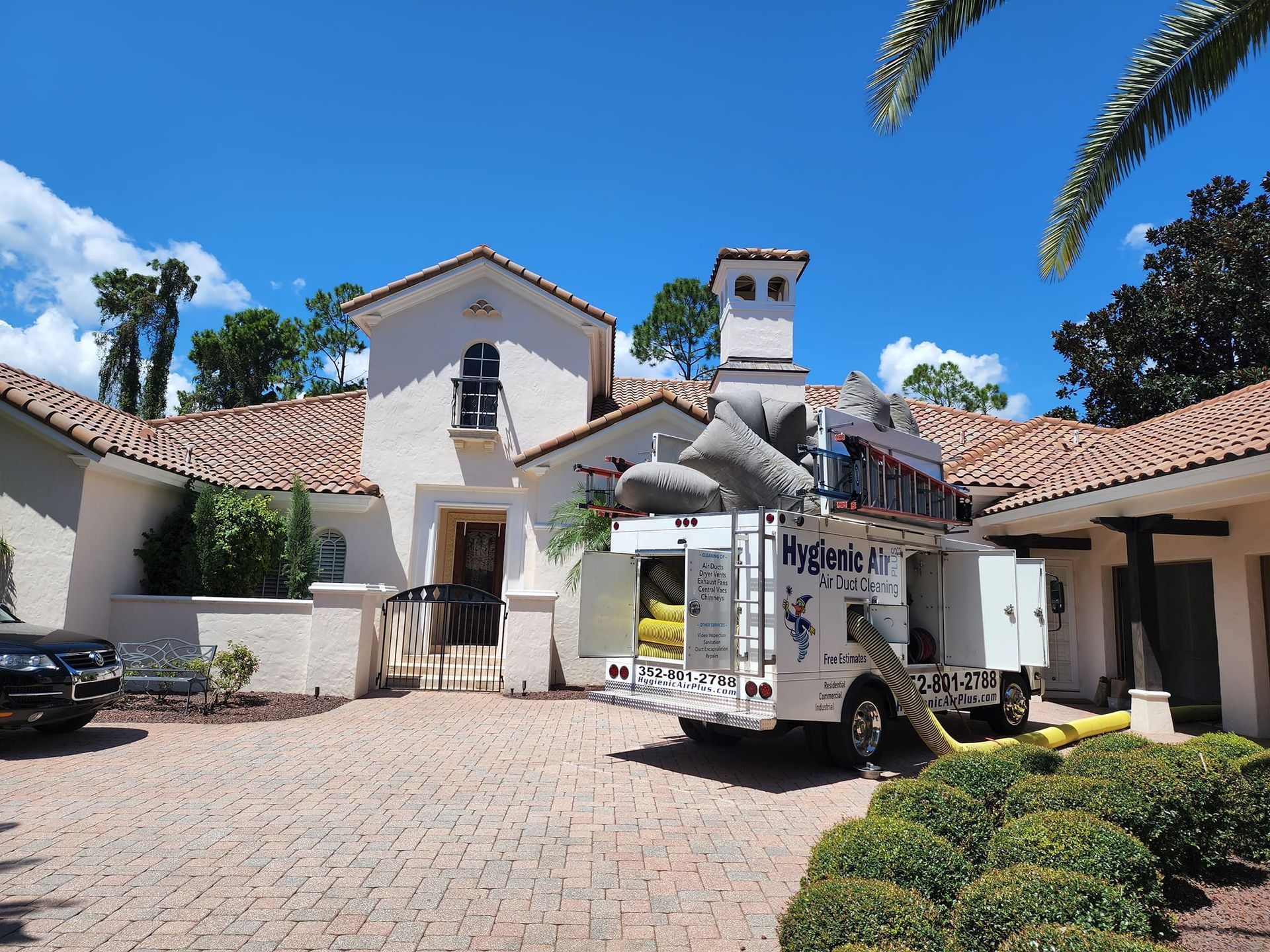 A white truck is parked in front of a large white house.