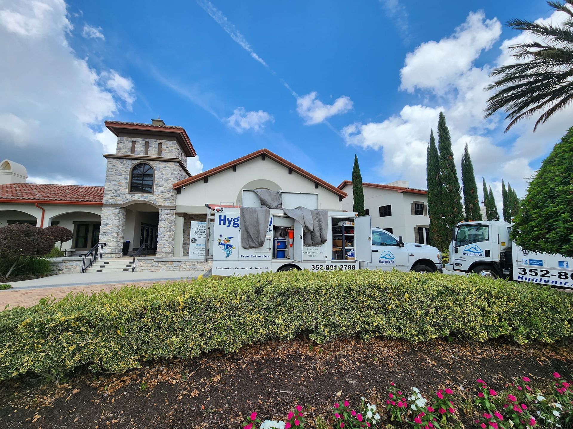 A white truck is parked in front of a large white building.