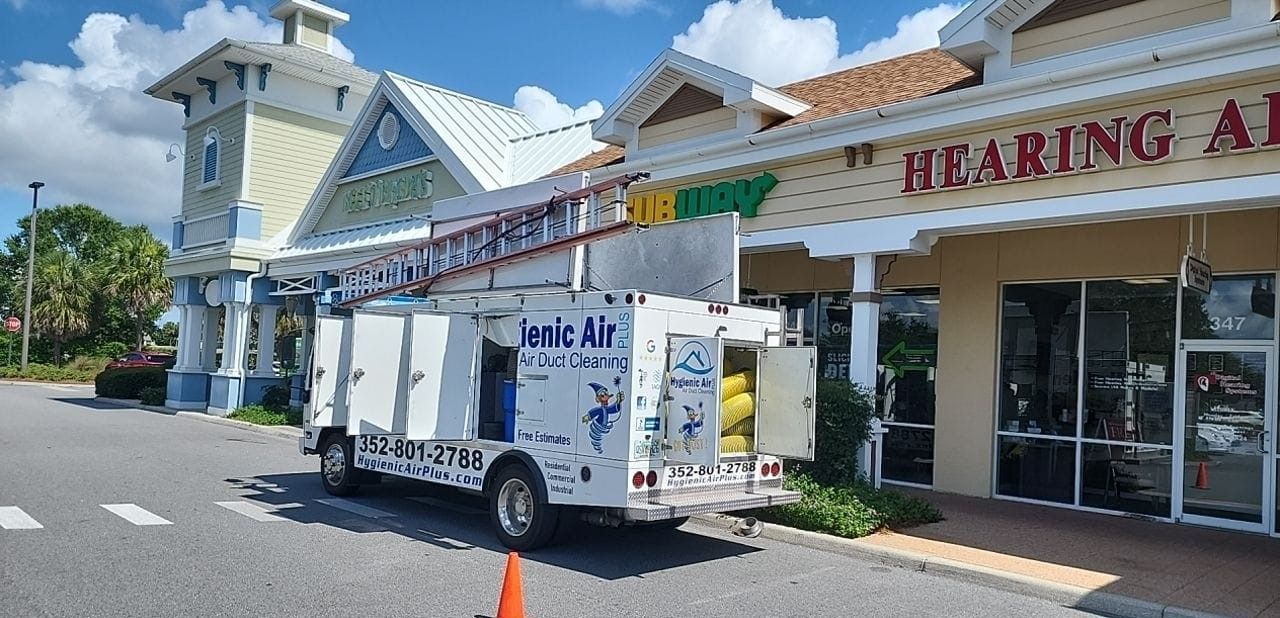 A hearing aid truck is parked in front of a building.