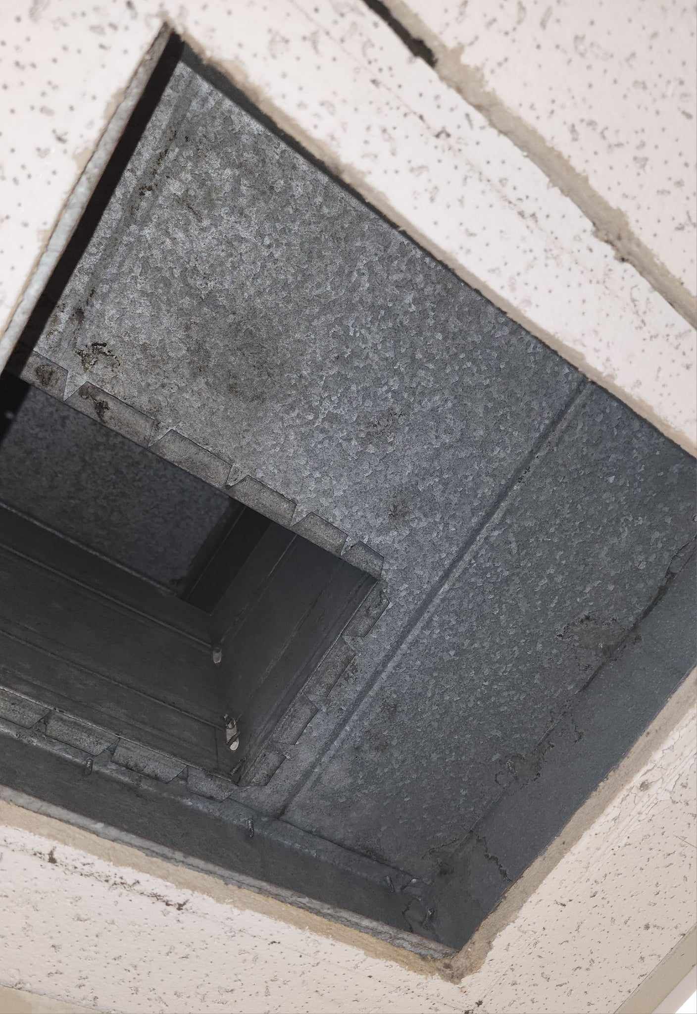 Looking up at a hole in the ceiling of a building.