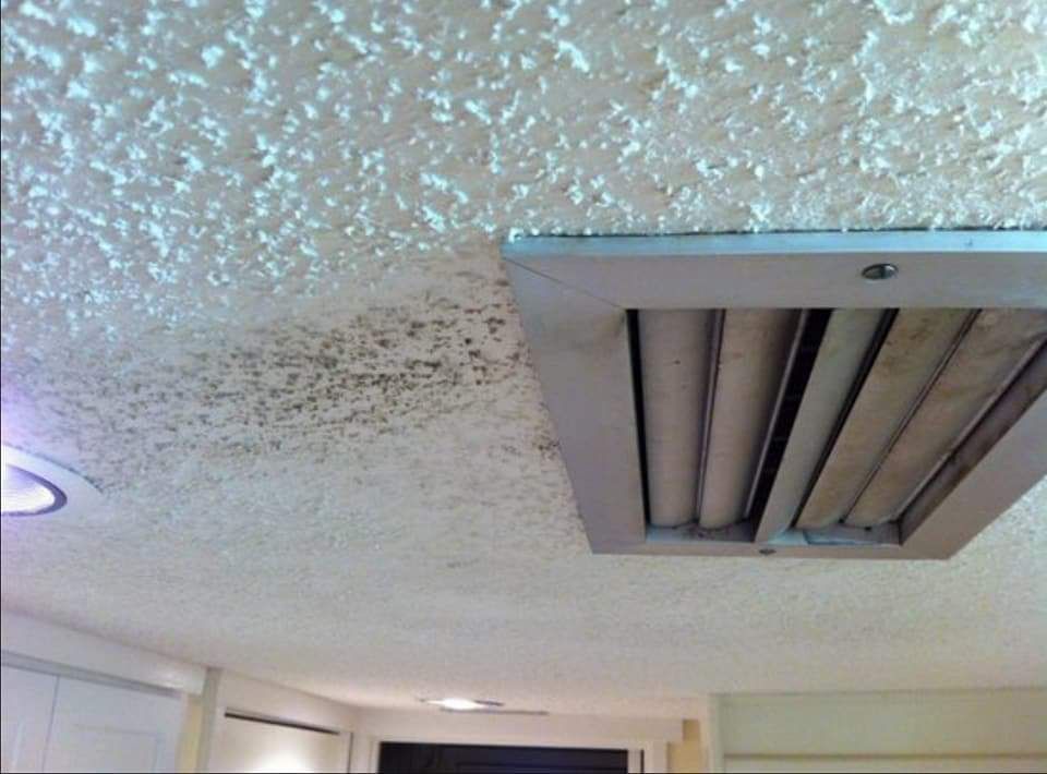 A ceiling with a ventilation grille on it