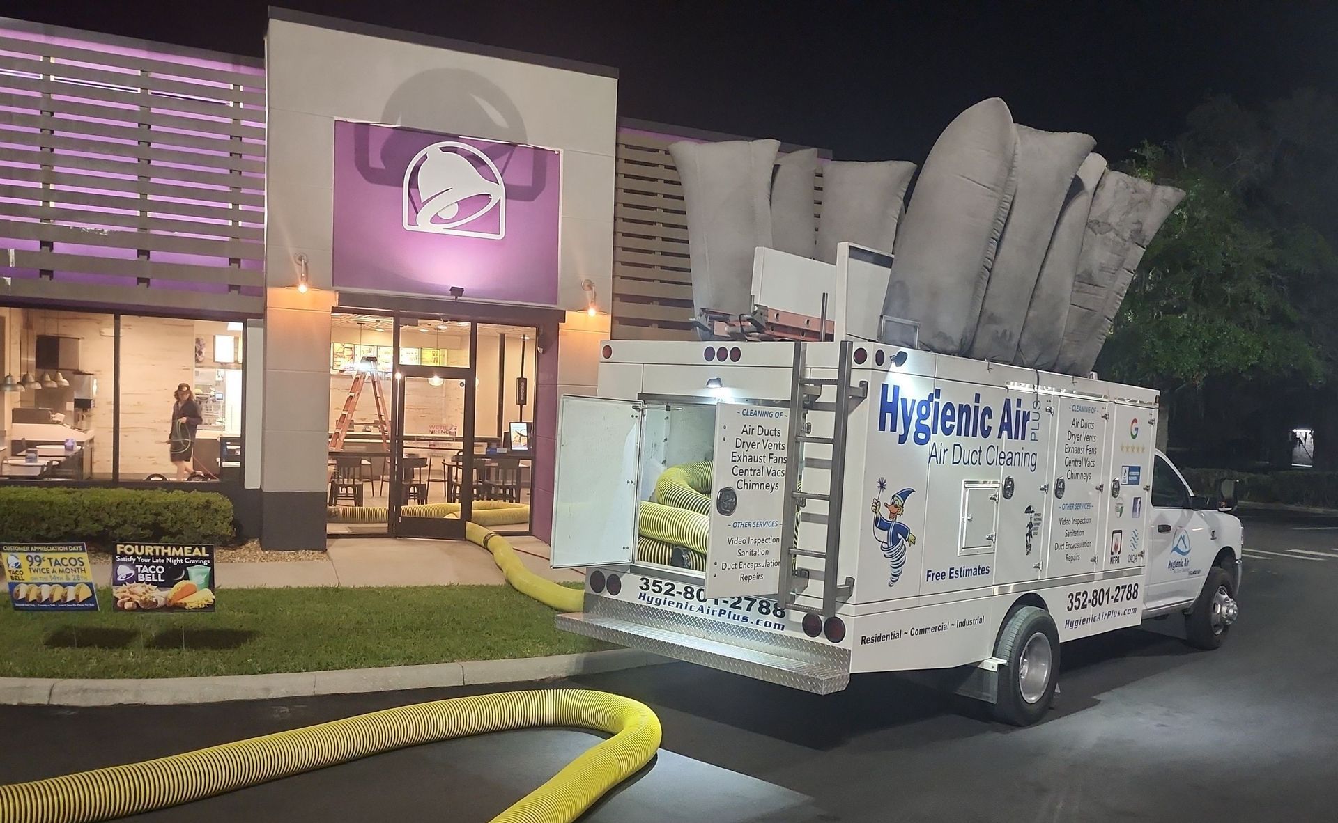 A white truck is parked in front of a taco bell restaurant.