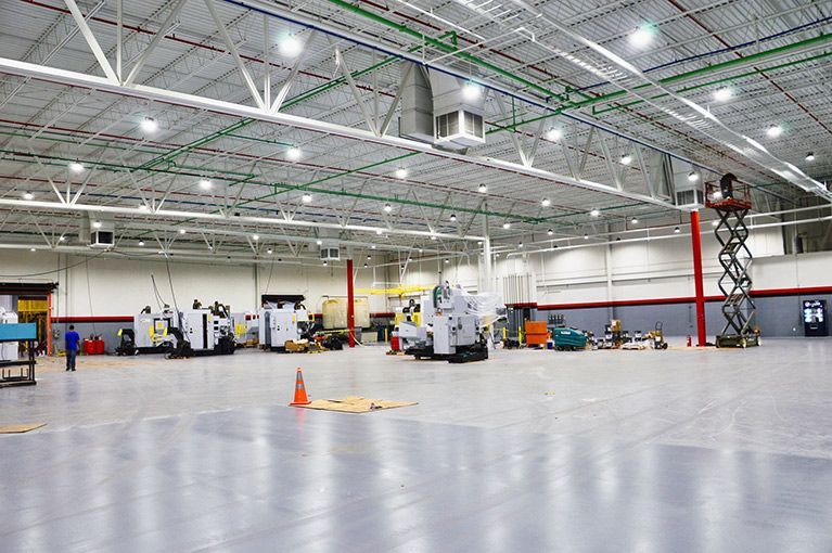 A large empty warehouse with a lot of machinery in it.