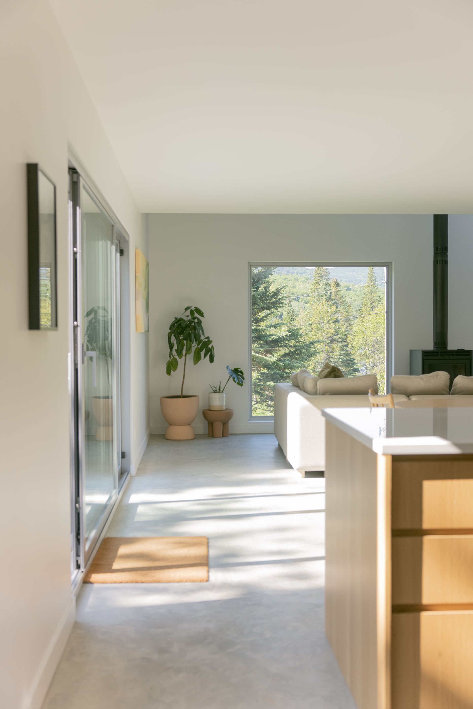 Une cuisine et un salon dans une maison avec une grande fenêtre.