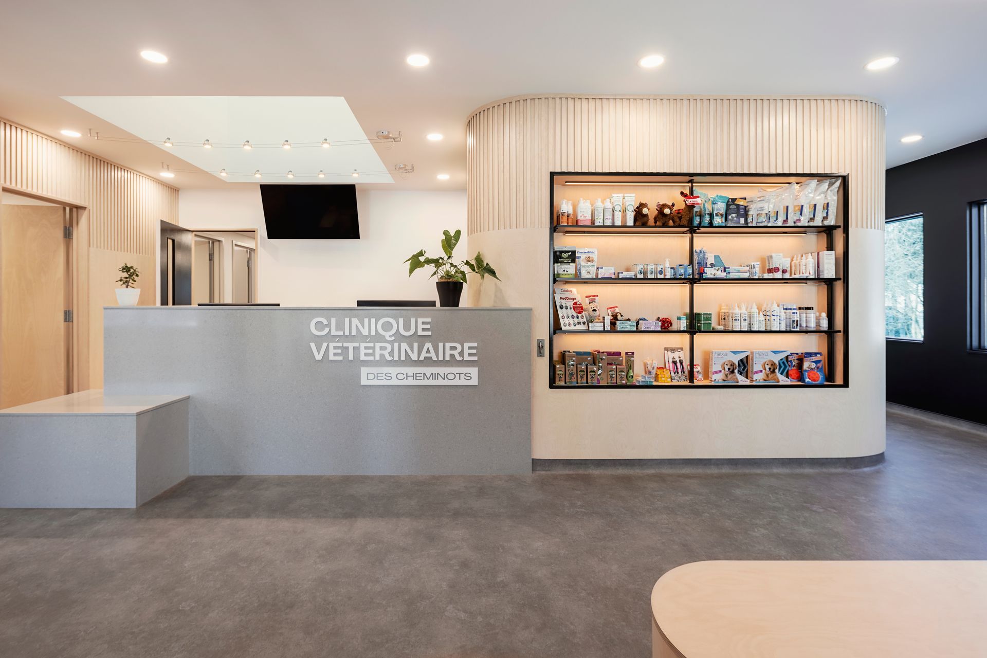 Un espace d'accueil d'une clinique vétérinaire avec un comptoir et des étagères.