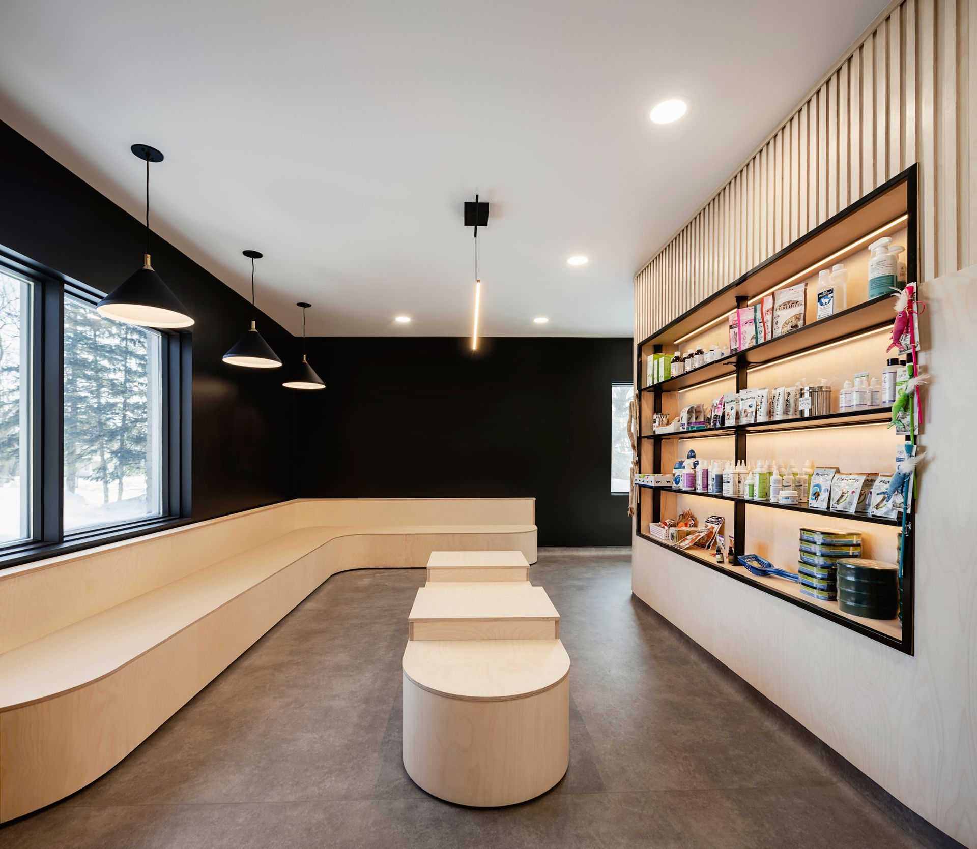 Une salle d'attente avec beaucoup d'étagères et de tables