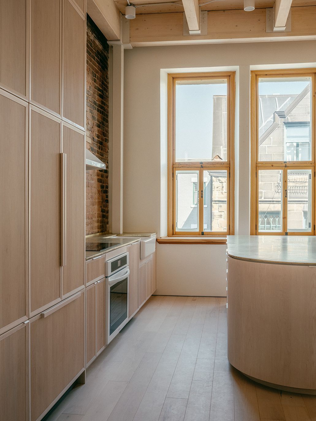 Une cuisine avec armoires en bois et un grand îlot au milieu de la pièce.