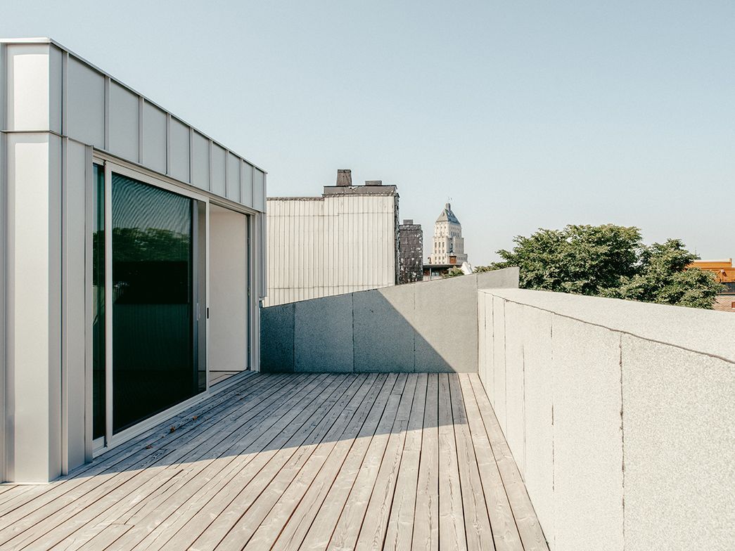 Un balcon avec une grande fenêtre et une terrasse en bois