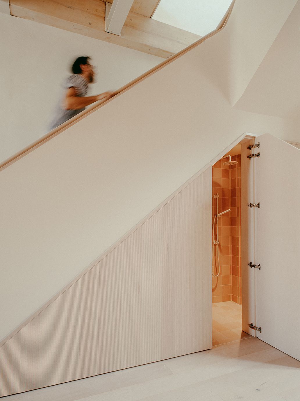 Une personne descend un escalier dans une maison.