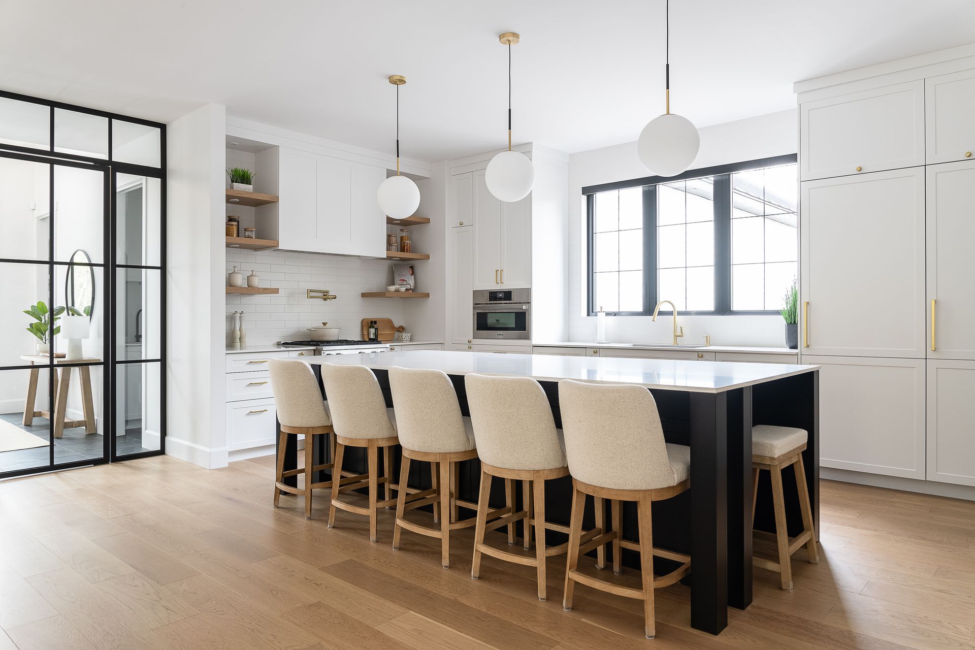 Une cuisine avec un grand îlot et beaucoup de chaises.