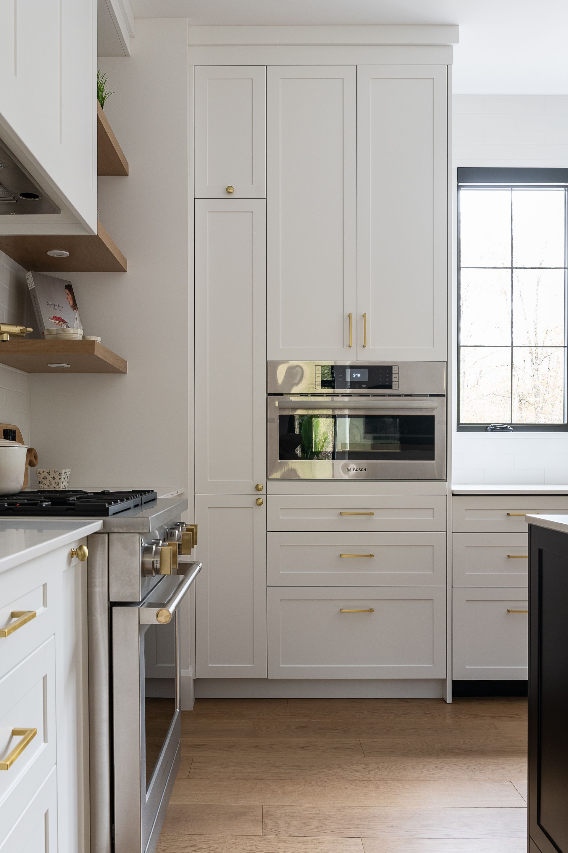 Une cuisine avec armoires blanches et appareils électroménagers en acier inoxydable.