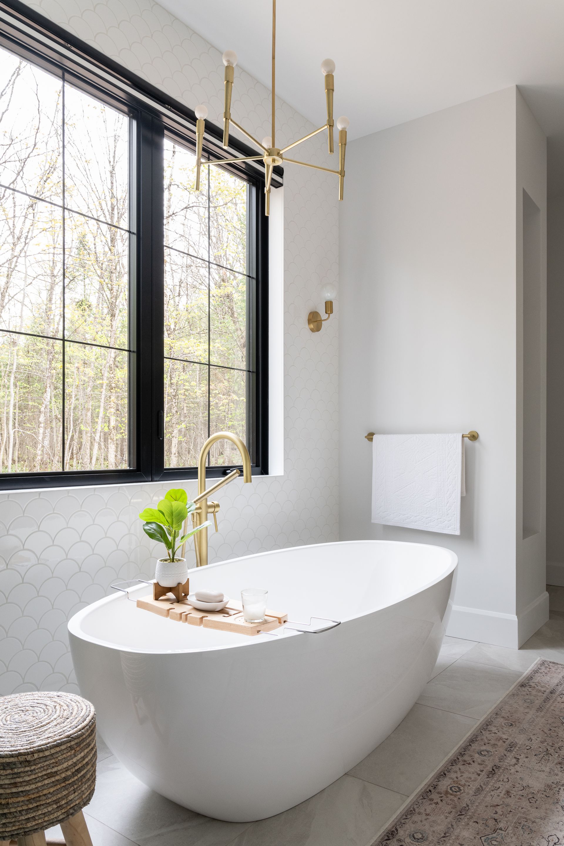 Une salle de bain avec baignoire et deux fenêtres.