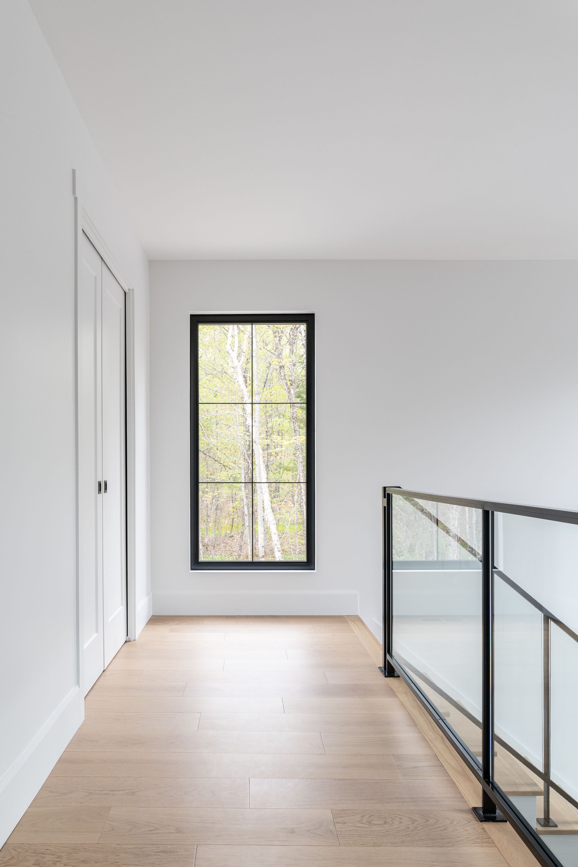 Un couloir vide avec une fenêtre et une balustrade