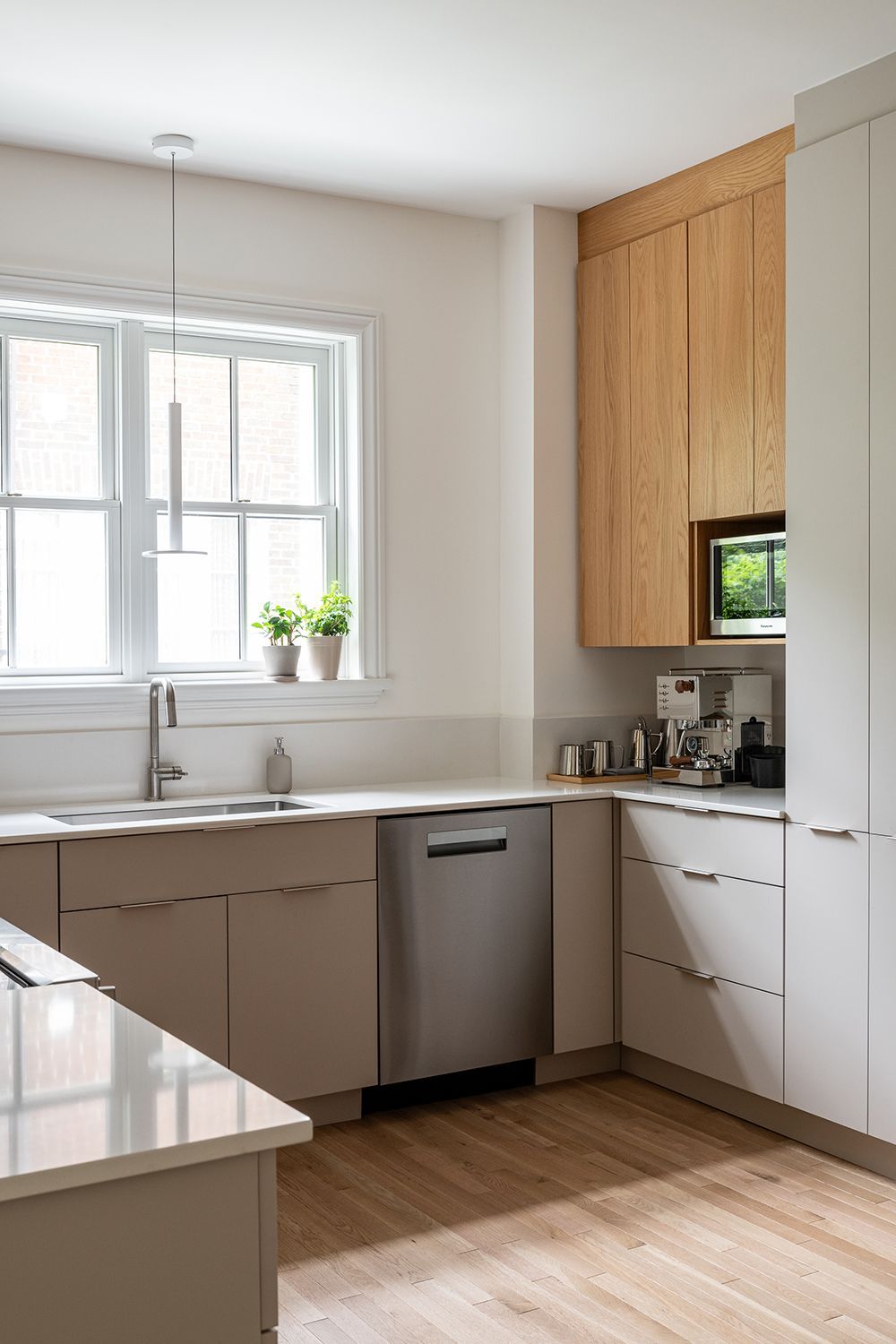 Une cuisine avec évier, lave-vaisselle et fenêtre.